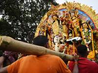 Indian laborers carry the idol of the Hindu goddess Durga before immersion from the river Ganges in Kolkata, India, on October 12, 2024. The...