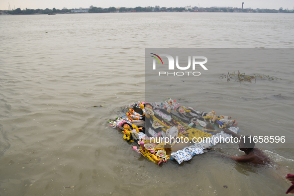 Hindu devotees immerse clay idols of Goddess Durga in the River Ganges in Kolkata, India, on October 12, 2024. The ten-day-long Hindu festiv...