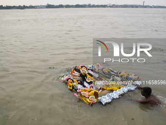 Hindu devotees immerse clay idols of Goddess Durga in the River Ganges in Kolkata, India, on October 12, 2024. The ten-day-long Hindu festiv...