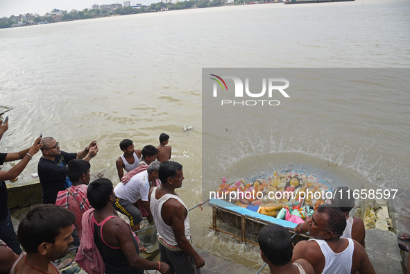 Hindu devotees immerse clay idols of Goddess Durga in the River Ganges in Kolkata, India, on October 12, 2024. The ten-day-long Hindu festiv...