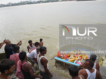 Hindu devotees immerse clay idols of Goddess Durga in the River Ganges in Kolkata, India, on October 12, 2024. The ten-day-long Hindu festiv...