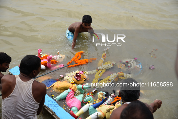 Hindu devotees immerse clay idols of Goddess Durga in the River Ganges in Kolkata, India, on October 12, 2024. The ten-day-long Hindu festiv...