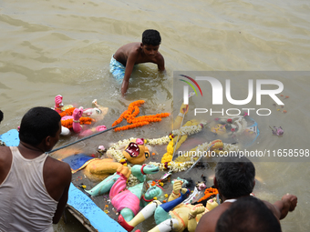 Hindu devotees immerse clay idols of Goddess Durga in the River Ganges in Kolkata, India, on October 12, 2024. The ten-day-long Hindu festiv...