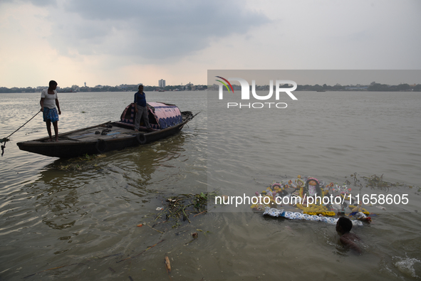 Hindu devotees immerse clay idols of Goddess Durga in the River Ganges in Kolkata, India, on October 12, 2024. The ten-day-long Hindu festiv...