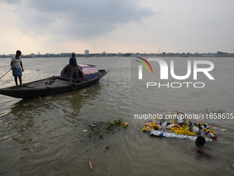 Hindu devotees immerse clay idols of Goddess Durga in the River Ganges in Kolkata, India, on October 12, 2024. The ten-day-long Hindu festiv...