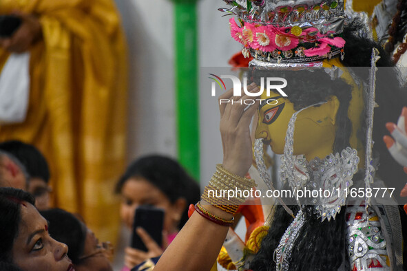 Married women offer their prayers for the last time to goddess Durga and immerse themselves in the ritual of ''Sindur Khela'' or vermillion...