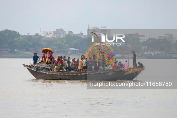 An idol of Goddess Durga is ferried to the middle of the river Ganges for immersion on the last day of the Durga Puja festival in Kolkata, I...