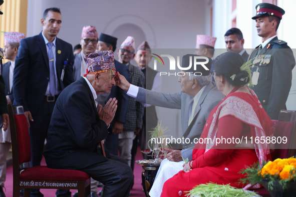 Nepal President Ram Chandra Paudel (in black cap) offers ''Tika'' to a member of the public at the Presidential palace in Kathmandu, Nepal,...