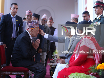 Nepal President Ram Chandra Paudel (in black cap) offers ''Tika'' to a member of the public at the Presidential palace in Kathmandu, Nepal,...