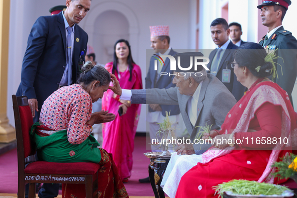 Nepal President Ram Chandra Paudel (in black cap) offers ''Tika'' to a member of the public at the Presidential palace in Kathmandu, Nepal,...