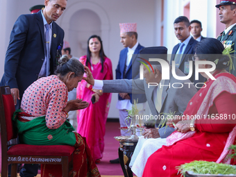 Nepal President Ram Chandra Paudel (in black cap) offers ''Tika'' to a member of the public at the Presidential palace in Kathmandu, Nepal,...