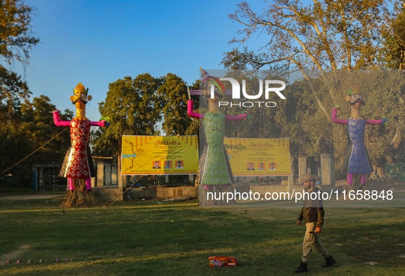 An Indian policeman walks near the effigies of the mythic demon king Ravana, his son Meghnath, and brother Kumbhkaran on the occasion of the...