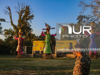 An Indian Paramilitary soldier takes a picture of effigies of the mythic demon king Ravana, his son Meghnath, and brother Kumbhkaran on the...