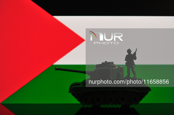 Illustration with figures of a soldier and a tank in front of a Palestine flag displayed on a computer screen is seen in L'Aquila, Italy, on...