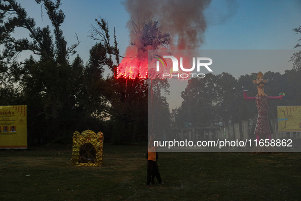 A man fires a cracker near effigies of the mythic demon king Ravana, his son Meghnath, and brother Kumbhkaran on the occasion of the Hindu f...