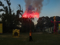 A man fires a cracker near effigies of the mythic demon king Ravana, his son Meghnath, and brother Kumbhkaran on the occasion of the Hindu f...