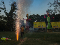 A man fires a cracker near effigies of the mythic demon king Ravana, his son Meghnath, and brother Kumbhkaran on the occasion of the Hindu f...