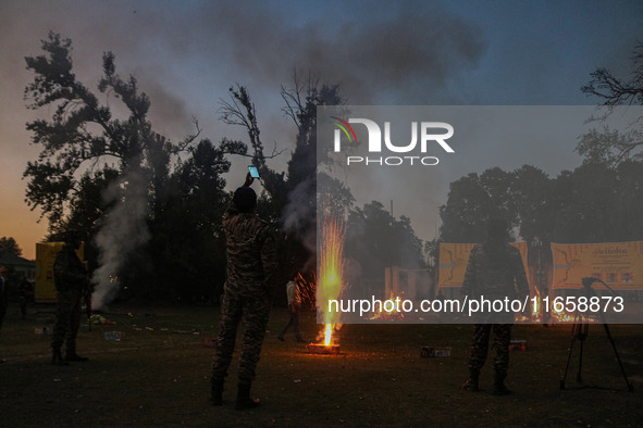 Indian paramilitary soldiers stand as fireworks explode on the occasion of the Hindu festival of Dussehra, which marks the triumph of good o...