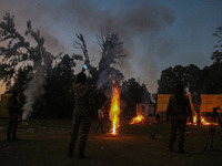 Indian paramilitary soldiers stand as fireworks explode on the occasion of the Hindu festival of Dussehra, which marks the triumph of good o...