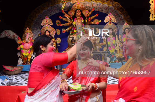 Hindu women apply vermilion powder to each other's faces as part of a ritual known as 'Sindoor Khela' on the occasion of the Dushhera-Vijaya...