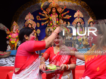 Hindu women apply vermilion powder to each other's faces as part of a ritual known as 'Sindoor Khela' on the occasion of the Dushhera-Vijaya...