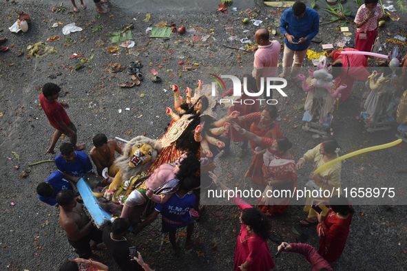 Devotees immerse an idol of the Hindu goddess Durga into the Ganges River on the last day of the Durga Puja festival in Kolkata, India, on O...