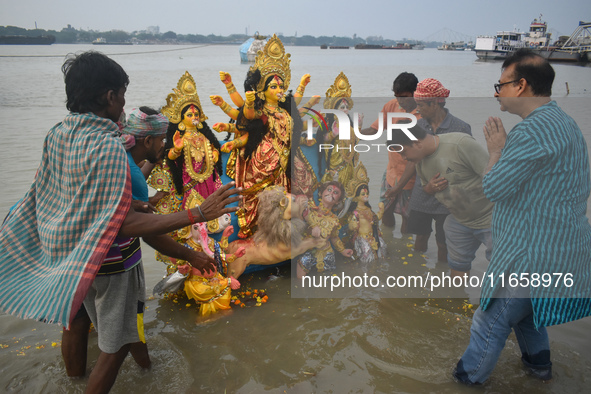 Devotees immerse an idol of the Hindu goddess Durga into the Ganges River on the last day of the Durga Puja festival in Kolkata, India, on O...