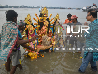 Devotees immerse an idol of the Hindu goddess Durga into the Ganges River on the last day of the Durga Puja festival in Kolkata, India, on O...