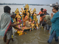 Devotees immerse an idol of the Hindu goddess Durga into the Ganges River on the last day of the Durga Puja festival in Kolkata, India, on O...