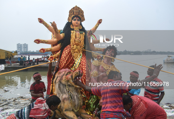 Devotees move an idol of the Hindu goddess Durga for immersion into the Ganges River, marking the last day of Durga Puja festival celebratio...