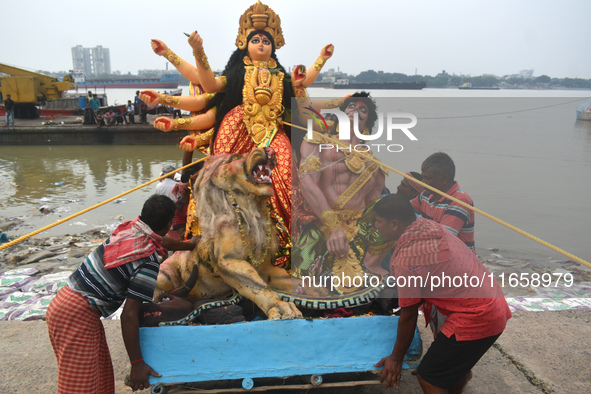 Devotees move an idol of the Hindu goddess Durga for immersion into the Ganges River, marking the last day of Durga Puja festival celebratio...