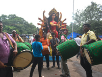 Traditional drummers play dhak in front of a Durga idol during immersion on the last day of the Durga Puja festival in Kolkata, India, on Oc...