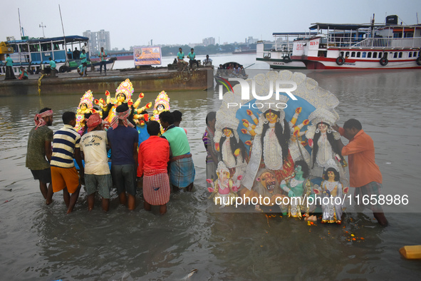 Devotees immerse idols of the Hindu goddess Durga into the Ganges River on the last day of the Durga Puja festival in Kolkata, India, on Oct...