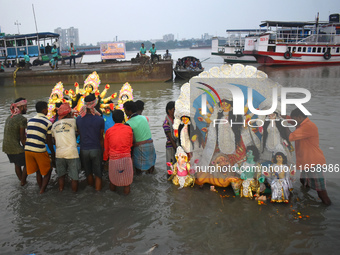 Devotees immerse idols of the Hindu goddess Durga into the Ganges River on the last day of the Durga Puja festival in Kolkata, India, on Oct...