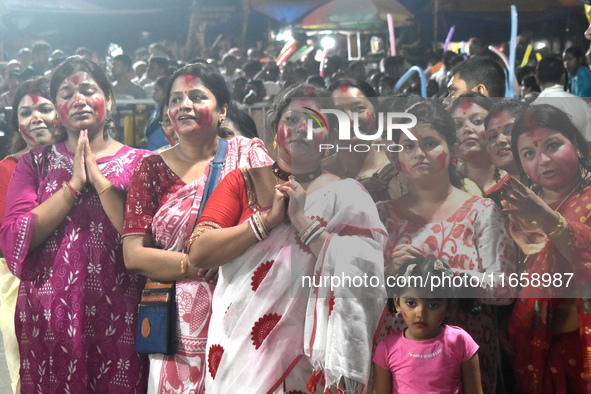 Devotees stand on the banks of the Ganges River to see the idol immersion on the last day of the Durga Puja festival in Kolkata, India, on O...