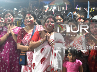 Devotees stand on the banks of the Ganges River to see the idol immersion on the last day of the Durga Puja festival in Kolkata, India, on O...