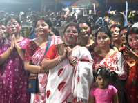 Devotees stand on the banks of the Ganges River to see the idol immersion on the last day of the Durga Puja festival in Kolkata, India, on O...