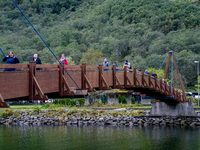 People walk on a bridge in Gudvangen, Norway, on September 17, 2024. The village of Gudvangen is a popular tourist destination located at th...