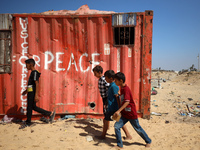 Palestinian children walk past a container amid the conflict between Israel and Hamas in Khan Younis, southern Gaza Strip, on October 12, 20...