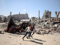 Palestinians walk near rubble and destroyed buildings amid the Israel-Hamas conflict in Khan Younis, in the southern Gaza Strip, on October...