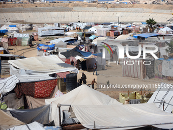 Displaced Palestinians shelter in a tent camp amid the Israel-Hamas conflict in Khan Younis, in the southern Gaza Strip, on October 12, 2024...