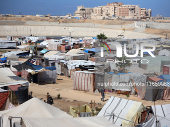 Displaced Palestinians shelter in a tent camp amid the Israel-Hamas conflict in Khan Younis, in the southern Gaza Strip, on October 12, 2024...