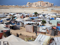 Displaced Palestinians shelter in a tent camp amid the Israel-Hamas conflict in Khan Younis, in the southern Gaza Strip, on October 12, 2024...