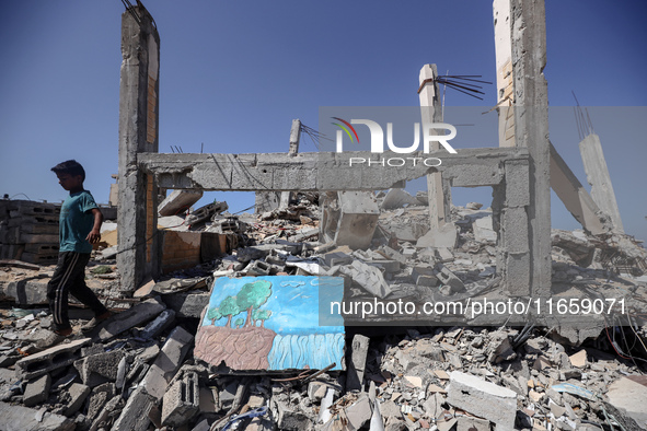 A boy walks near rubble and destroyed buildings amid the Israel-Hamas conflict in Khan Younis, in the southern Gaza Strip, on October 12, 20...