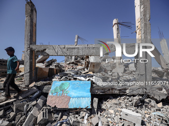 A boy walks near rubble and destroyed buildings amid the Israel-Hamas conflict in Khan Younis, in the southern Gaza Strip, on October 12, 20...