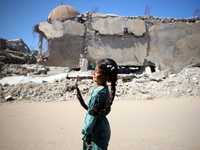 A Palestinian girl walks beside a mosque after it is bombed in an Israeli airstrike in Khan Younis, southern Gaza Strip, on October 12, 2024...