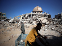 Palestinians walk past a mosque after it is hit in an Israeli strike in Khan Younis, in the southern Gaza Strip, on October 12, 2024, amid t...