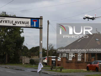 Sign with inscription of Myrtle Avenue with an aircraft in the background. British Airways Boeing 787-8 Dreamliner aircraft spotted flying o...