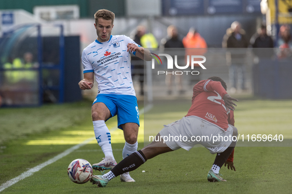 Andrew Dallas of Barrow competes with David Tutonda of Morecambe during the Sky Bet League 2 match between Barrow and Morecambe at Holker St...