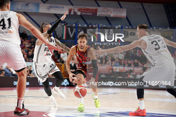 Umana Reyer's Davide Moretti competes against Virtus Bologna's Achille Polonara and Daniel Hackett during the Italian LBA basketball champio...